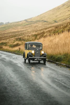 äldre bil kör ner för gata